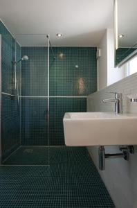 ein Bad mit einer Glasdusche und einem Waschbecken in der Unterkunft 1463 Apartmenthaus in Karlsruhe