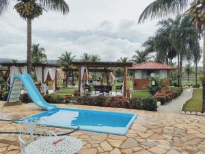 a resort with a slide and a swimming pool at Pousada Lago Azul in Delfinópolis
