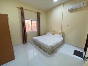 a bedroom with a bed in a room with a window at RED Tag Salalah in Salalah