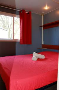 1 dormitorio con cama roja y cortina roja en Les gîtes de camargue, en Le Cailar