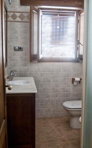 baño con lavabo y aseo y ventana en Casa Rural Campoamor en Riópar