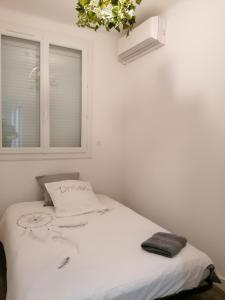 Ce lit se trouve dans un dortoir blanc doté d'une fenêtre. dans l'établissement SETE VUE EXCEPTIONNELLE, à Sète