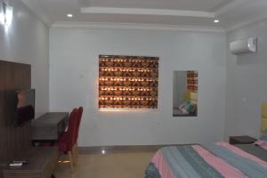 a bedroom with a bed and a desk and a painting on the wall at Kay's ville Apartment in Abuja