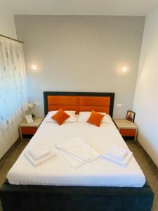 a bedroom with a large white bed with orange pillows at Orange House Constanta in Constanţa