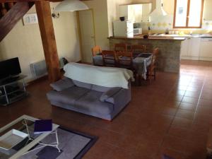 a living room with a couch and a kitchen at Les Reves B&B Chambres d'Hotes et Table d'Hotes in Arques