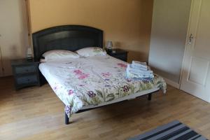 1 dormitorio con 1 cama con colcha de flores en Les Reves B&B Chambres d'Hotes et Table d'Hotes en Arques