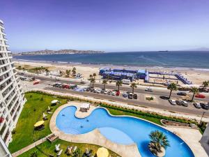 an aerial view of a resort with a pool and a beach at condominio costa peñuelas torre 2 in Coquimbo