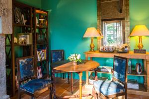una mesa y sillas en una habitación con una pared verde en Domaine de Labarthe Maison d'hotes en Espère