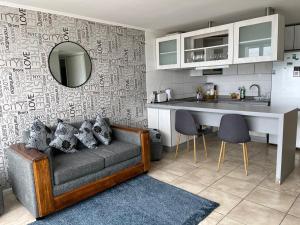 a living room with a couch and a kitchen at condominio costa peñuelas torre 2 in Coquimbo