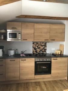 a kitchen with wooden cabinets and a microwave at Gasthof Zum Ott in Staudach-Egerndach