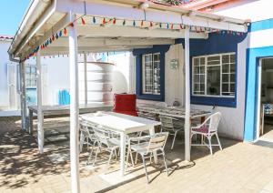 a patio with tables and chairs under a pergola at Mr Pell's House Self-Catering Accommodation in Jeffreys Bay