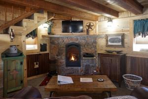 a living room with a fireplace in a log cabin at Return to Lonesome Dove in South Fork