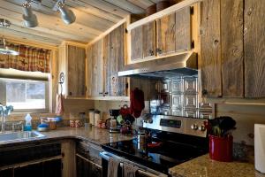 a kitchen with wooden cabinets and a stove top oven at Return to Lonesome Dove in South Fork