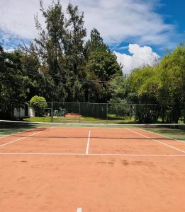 a tennis court with a net on it at La Mirage Garden Hotel & Spa in Cotacachi