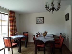 a dining room with tables and chairs and a chandelier at Retro Regina in Bazna
