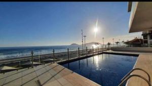 a swimming pool with a view of the ocean at Departamento en malecon Portico Beach in Mazatlán