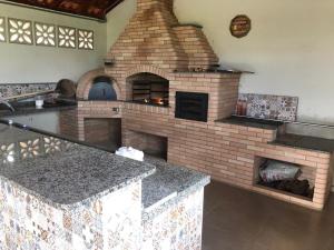 La cocina está equipada con horno de ladrillo y encimera. en Sitio em Atibaia - Sitio Beija-Flor, en Atibaia