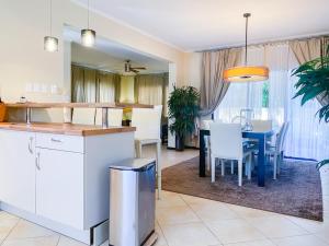eine Küche und ein Wohnzimmer mit einem Tisch und Stühlen in der Unterkunft Diamante 165 Luxury Villa with Private Pool in Gold Coast 3 Bedrooms 3 Bath in Palm-Eagle Beach