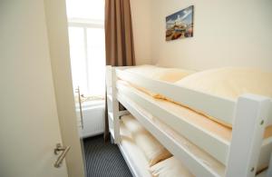 a bedroom with two beds and a window at Apartment Eisberg 4 mit Balkon in Norderney