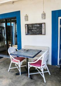 una mesa con 2 sillas y una pizarra en la pared en Mr Pell's House Self-Catering Accommodation, en Jeffreys Bay