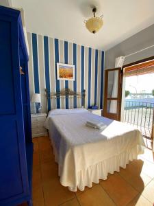 a bedroom with a bed with blue and white stripes at Pensión Cristina in El Rocío