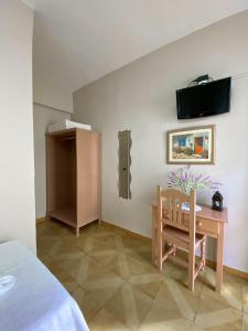 a bedroom with a table and a chair and a tv at Pensión Cristina in El Rocío