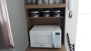 eine Mikrowelle in der Küche in der Unterkunft Edificio Belio in Cascavel