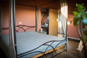ein Schlafzimmer mit einem Himmelbett in einem Zimmer in der Unterkunft B&B Buytenshuys in Hooglede