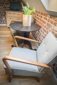 een tafel en stoelen met een potplant erop bij B&B Buytenshuys in Hooglede