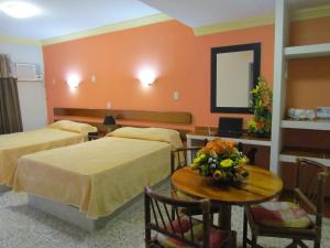 a hotel room with two beds and a table and a mirror at Hotel San Angel Cerca Del Acuario in Veracruz +37 photos