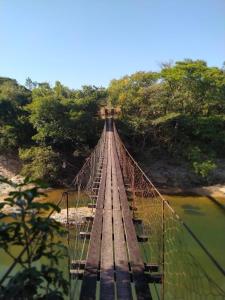 eine Hängebrücke über einen Wasserkörper in der Unterkunft Pousada Serra Da Canastra in Vargem Bonita