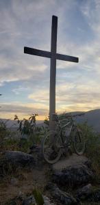 ein Fahrrad, das neben einem Kreuz auf einem Hügel parkt in der Unterkunft Pousada Serra Da Canastra in Vargem Bonita