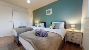 a bedroom with two beds with towels on them at Spacious 2 Bedroom Corporate Apartment by Srk Serviced Accommodation in Eye