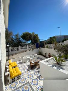 un patio con sedie a sdraio gialle e tavolo di Casa Puntamare a Peschici