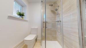 a bathroom with a toilet and a glass shower at Spacious 2 Bedroom Corporate Apartment by Srk Serviced Accommodation in Eye