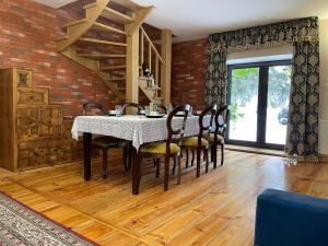 a dining room with a table and chairs and a brick wall at Willa nad Pilicą in Promna