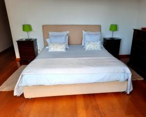 una camera da letto con un grande letto con due comodini di Villa Sol e Mar Garajau Madeira a Caniço