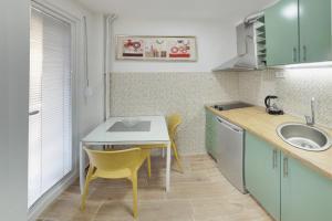 a small kitchen with a table and a sink at Bibi's Apartments in Skopje