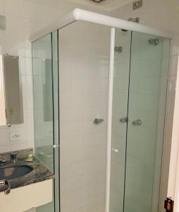 Un baño con ducha de cristal y lavabo. en Refúgio Alpino Economy, en Campos do Jordão