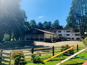un granero con una valla y un edificio en Refúgio Alpino Economy, en Campos do Jordão