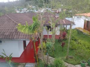 una casa rossa e bianca con alberi di fronte di La Posada de Cuispes a Cuispes