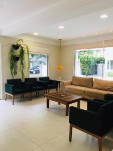 a living room with a couch and chairs and a table at Caravaggio Praia Hotel in Florianópolis