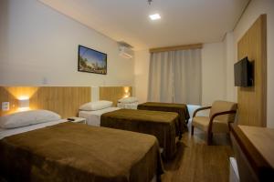 Tri Hotel Chapecó tesisinde bir odada yatak veya yataklar