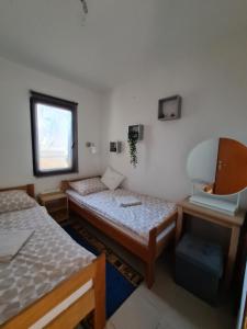 two beds in a room with a mirror and a sink at Apartmani Bellevue in Vir