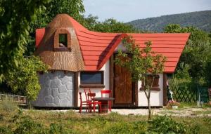 een klein huis met een rood dak en een tafel en stoelen bij Krka Fairytale Little Castle in Skradin