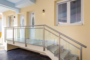une rampe en verre sur un escalier dans une maison dans l'établissement ALDEBARAN HOMES, à Limenaria