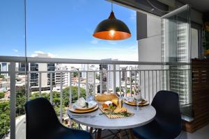 a table with food on a balcony with a view of the city at Edificio Summit Pinheiros Best Location in São Paulo Balcony with City Views Pool, Fitness Room and Parking Garage 3 minutes to Subway in Sao Paulo