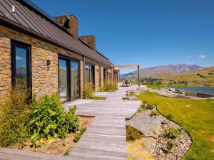 una pasarela junto a un edificio con montañas en el fondo en Sicilian Luxury Retreat, en Queenstown