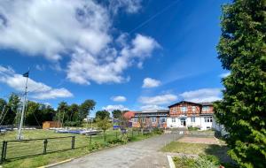 un edificio con una valla delante de un aparcamiento en Pension Zum Alten Fährhaus, en Rostock