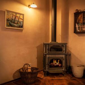 a wood stove in a room with two baskets at Castellino Bella Vista in Ponte Tresa
